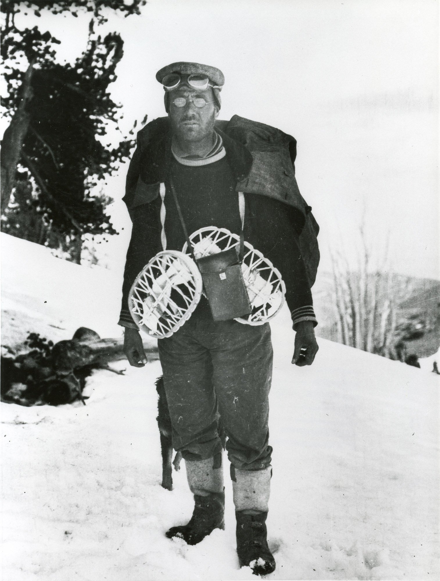 openai Professor James E. Church wearing goggles and snowshoes, standing on a snowy hillside