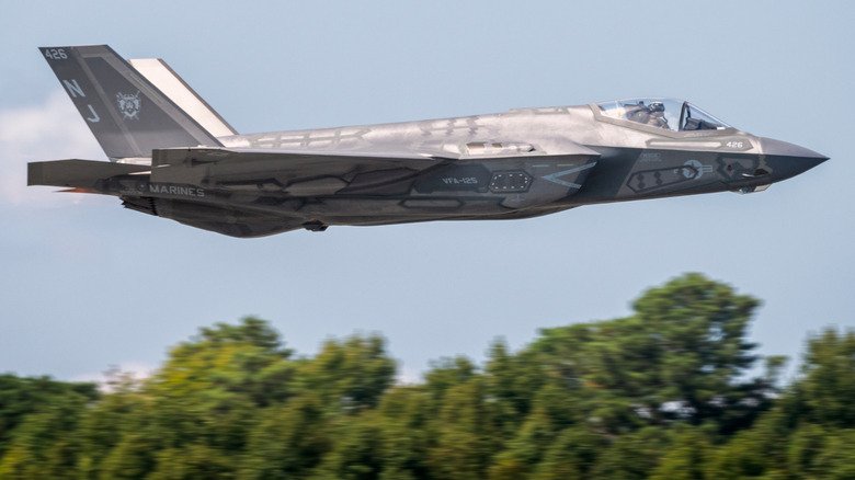 openai An F-35 Lightning II in mid-flight over trees